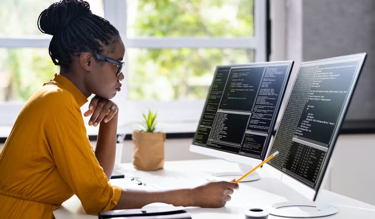 Software Engineers lady working on her PC and display screen