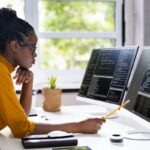 Software Engineers lady working on her PC and display screen