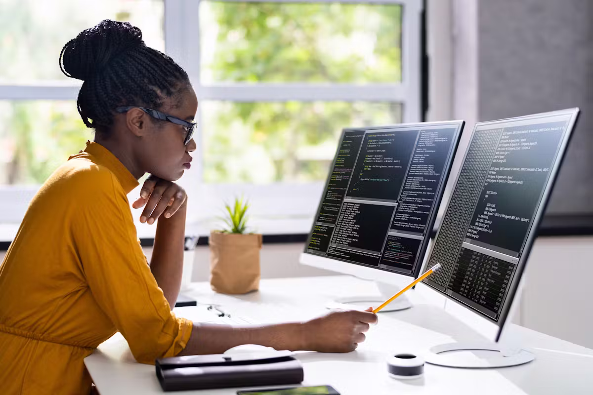 Software Engineers lady working on her PC and display screen